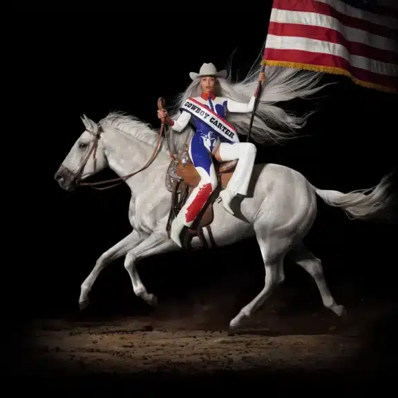 Beyonce riding a horse while holding an American flag