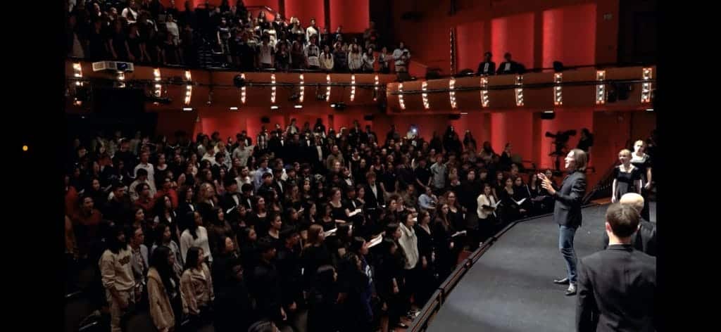Eric Whitacre turning away from the choir and conducting the audience of Montclair students.