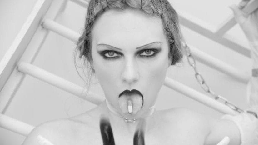 Taylor Swift with a pill on her tongue.