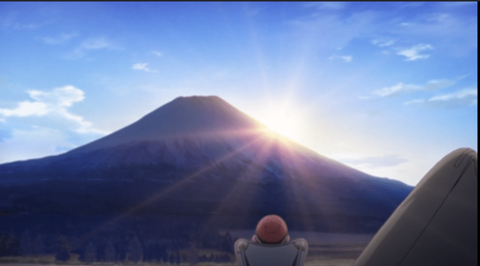 A girl sits on a chair facing backwards in the grass. Mt Fuji, the famous japanese volano, towers before her and the sun rises from behind it into the blue sky.