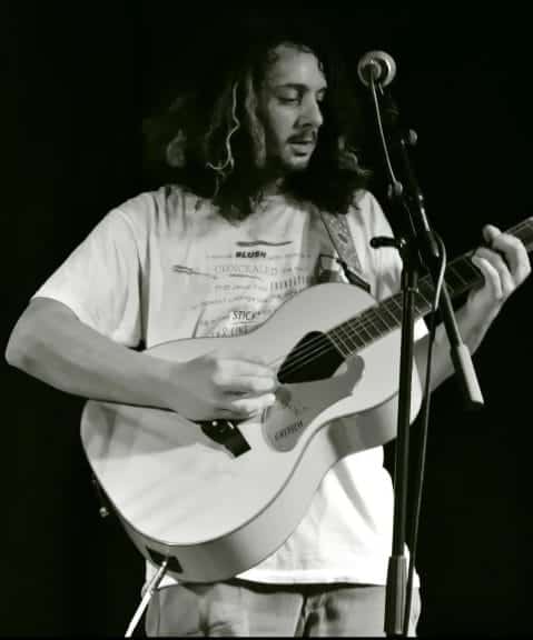 Jay from Crywank playing the guitar in a black and white image