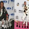 Side by side photos. The photo on the left shows a black man in a black suit and white shirt kneels in front of a row of silver trophies in front of a blue and white background. The photo on the right shows a mixed race man in a white suit clutching several gold trophies with more trophies in front of him in front of a pink carpet and a white backdrop