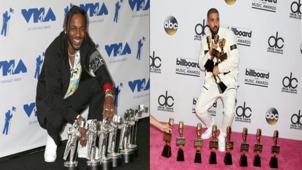 Side by side photos. The photo on the left shows a black man in a black suit and white shirt kneels in front of a row of silver trophies in front of a blue and white background. The photo on the right shows a mixed race man in a white suit clutching several gold trophies with more trophies in front of him in front of a pink carpet and a white backdrop