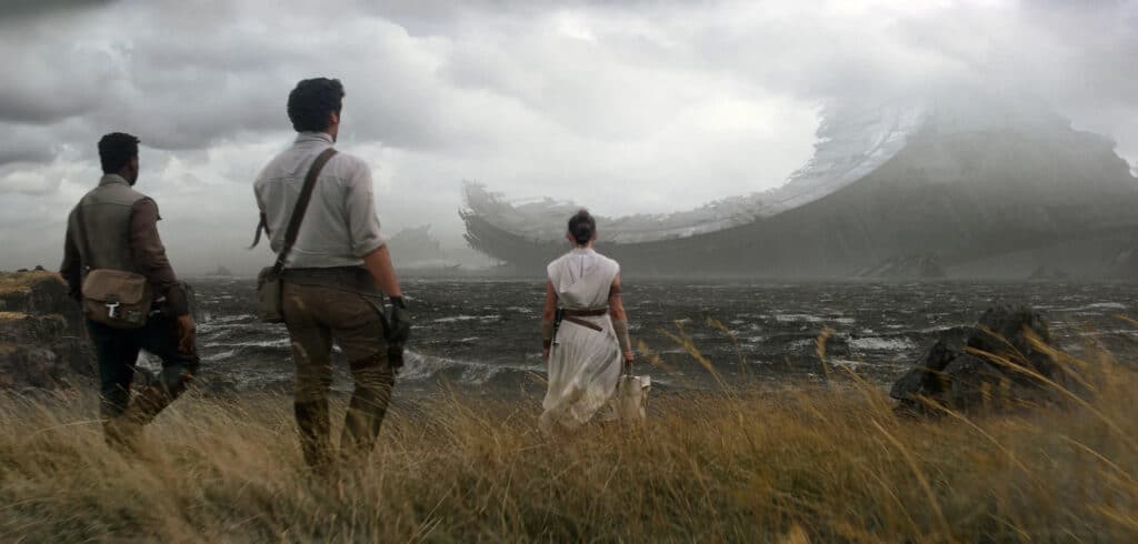 Rey (Daisy Ridley), Finn (John Boyega), and Poe (Oscar Isaac) stand and gaze at the wreckage of the Death Star.