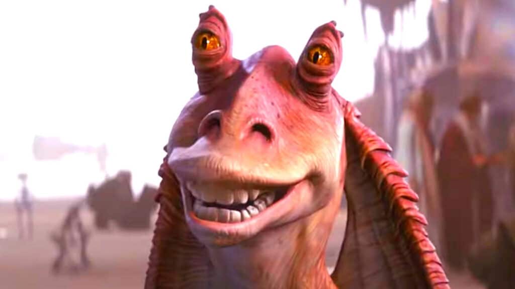 Jar Jar Binks (Ahmed Best) smiling at a garage on Tatooine.