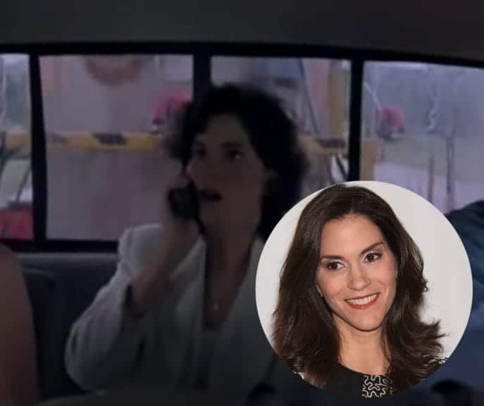 A woman with brown hair in an 80s white blazer holds a phone to her head with a shocked expression on her face. in the bottom-right corner there is a photo of the woman in a circle, she has brown hair, wrinkles and is smiling