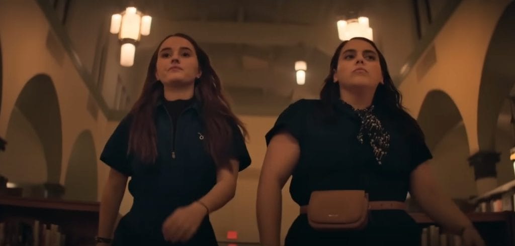 The two main characters of Booksmart walk in slow motion in their matching outfits with confident looks on their faces.