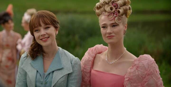 Eloise, a young, white, brunette woman smiles. Cressida, a young, white, blond woman looks forward with a serious expression.