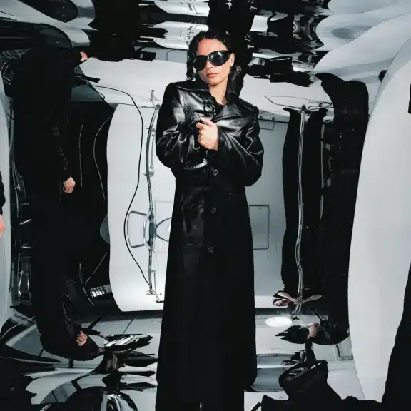 Erika De Casier in black latex trench coat