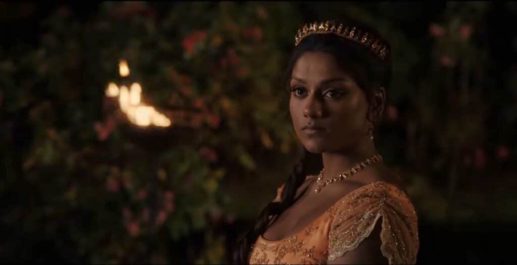 Kate Sharma in an orange gown and a tiara.