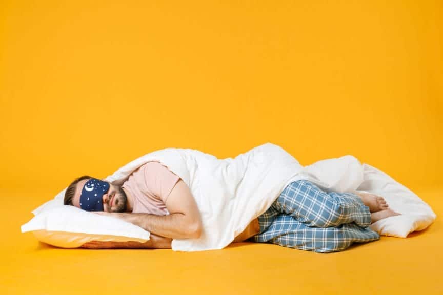a man sleeps on his side against a yellow background sleep quality