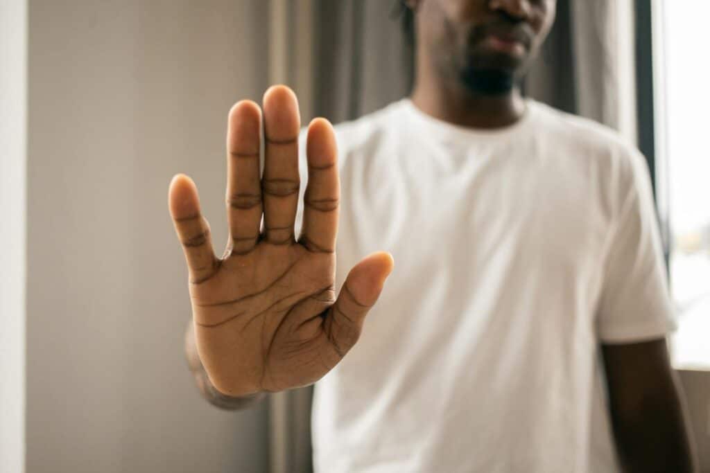 Man gesturing stop to represent boundaries for the transition back home.