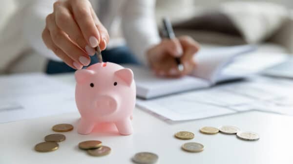 woman putting coins in a piggy bank