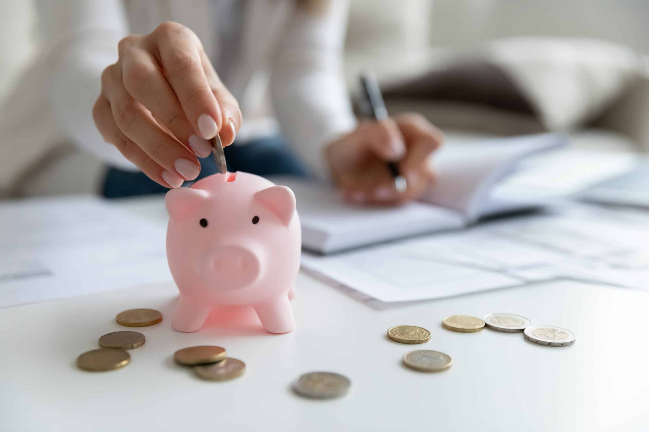 woman putting coins in a piggy bank