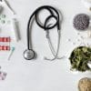 Western medicine on one half of the image and herbal remedies not he other with a stethoscope in the middle.