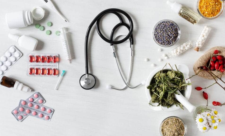 Western medicine on one half of the image and herbal remedies not he other with a stethoscope in the middle.