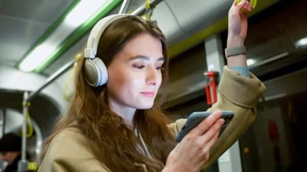 A woman with headphones on watching video essays.