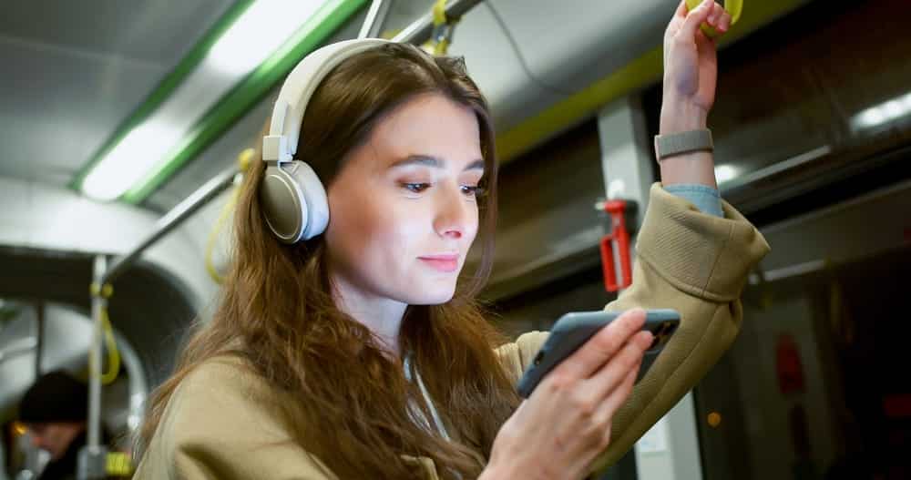 A woman with headphones on watching video essays.