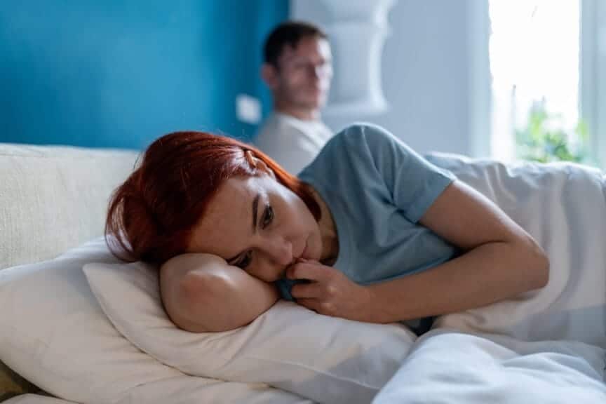 Toxic relationship, couple sitting in bed angry