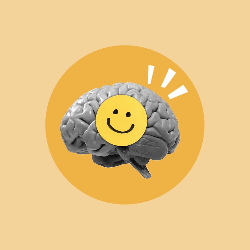 A brain with a smiley face on it, conveying emotions of happiness. Yellow background.