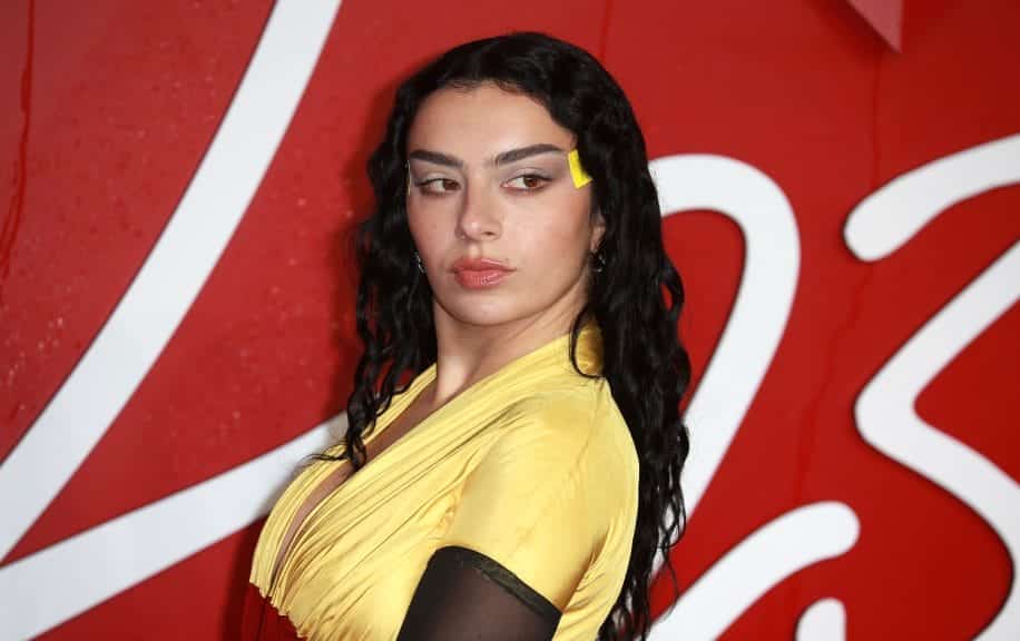 Charli XCX on the red carpet in a yellow dress