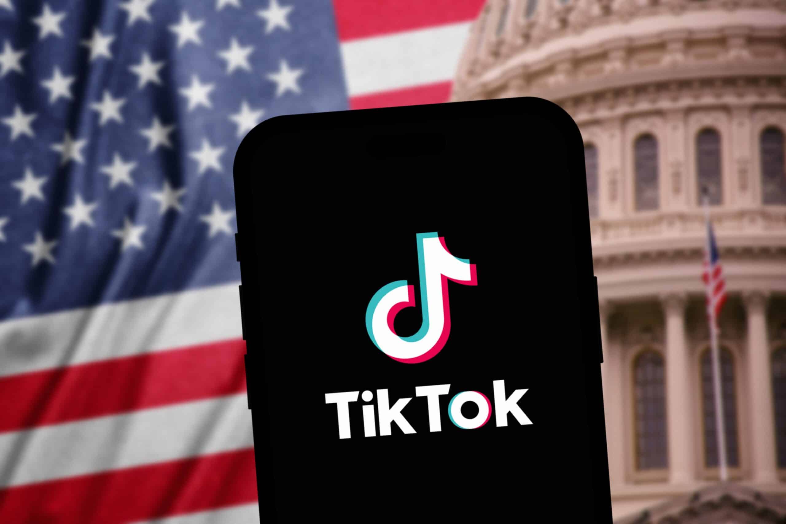 Phone opening TikTok in front of American flag and Capitol Building background