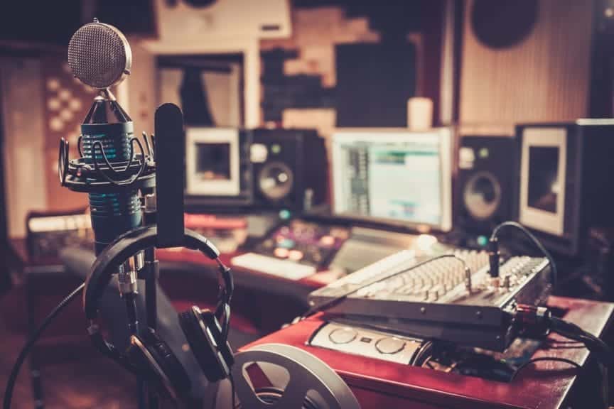 Close-up of boutique recording studio control desk with headset, microphone, and computers