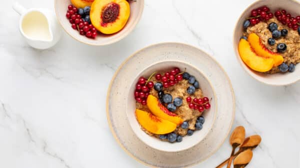 top down view of bowls with oatmeal and fruit on a clean surface