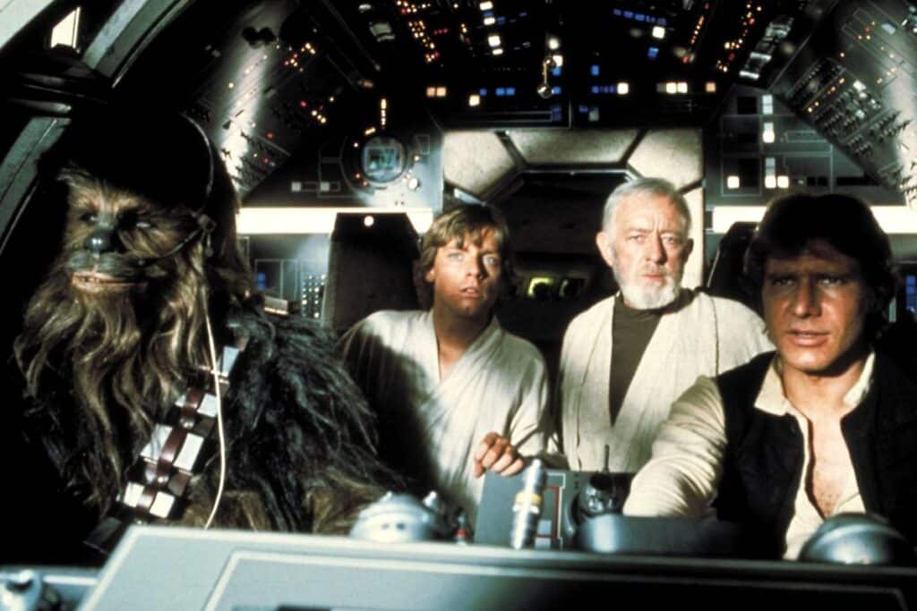Peter Mayhew, Mark Hamill, Alec Guinness, and Harrison Ford in Star Wars: Episode IV – A New Hope.