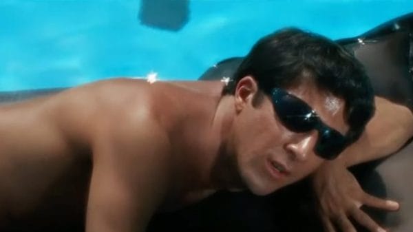 Dustin Hoffman as Ben, in The Graduate, lounges on a floatie in the pool wearing sunglasses.