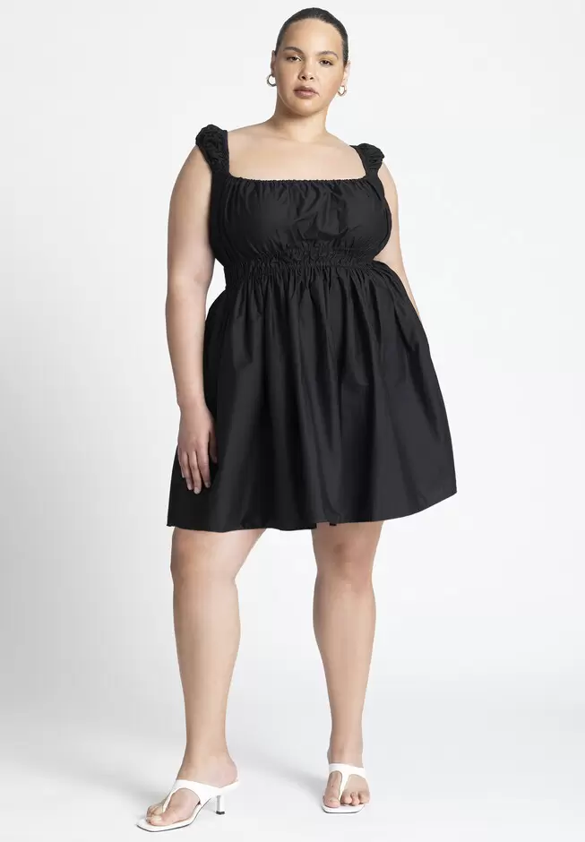 Model wearing a short, black, poplin dress. 