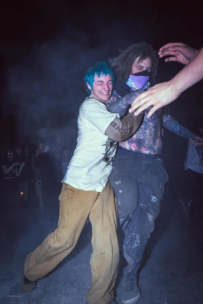 Two people in the middle of moshing, one with a large smile on his face.