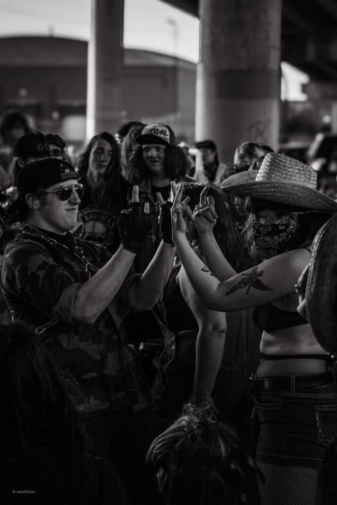 Two show-goers flipping each other off in a friendly manner.