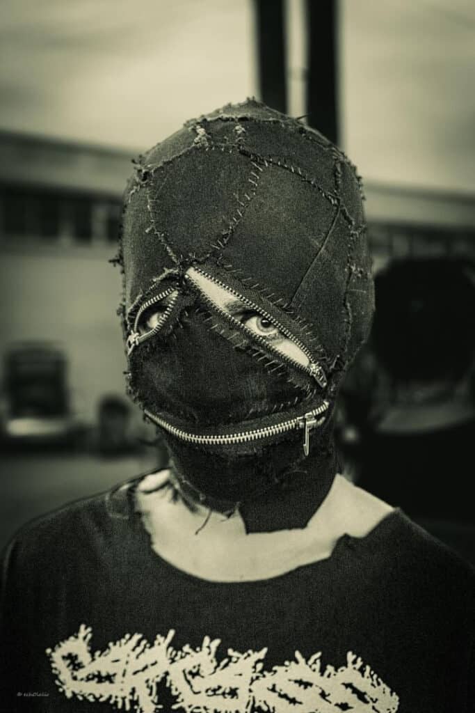 A punk fan in a homemade balaclava mask made from what looks like denim