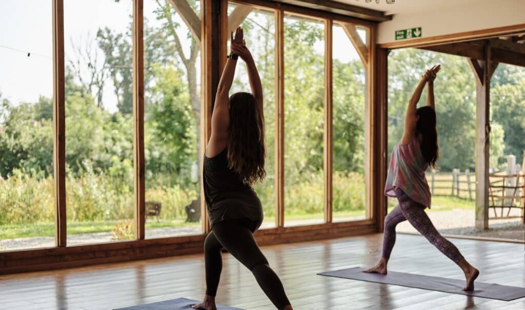 photo of two people doing yoga