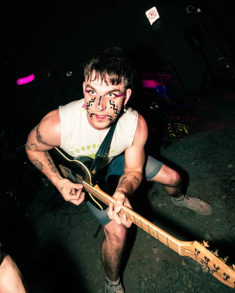 A photo of a punk musician in vibrant, abstract makeup.
