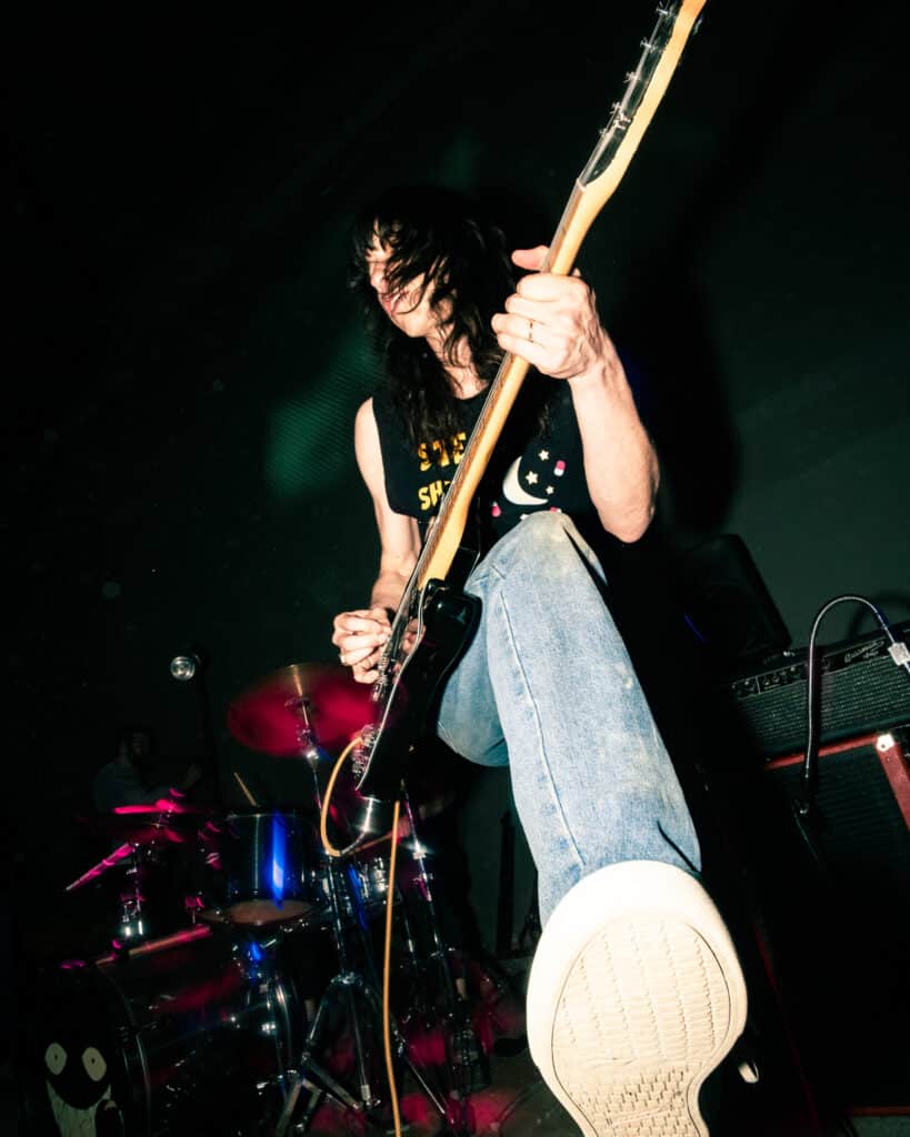A low-angle capture of a punk musician performing.