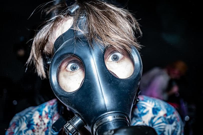 A punk show attendee in a gas mask.