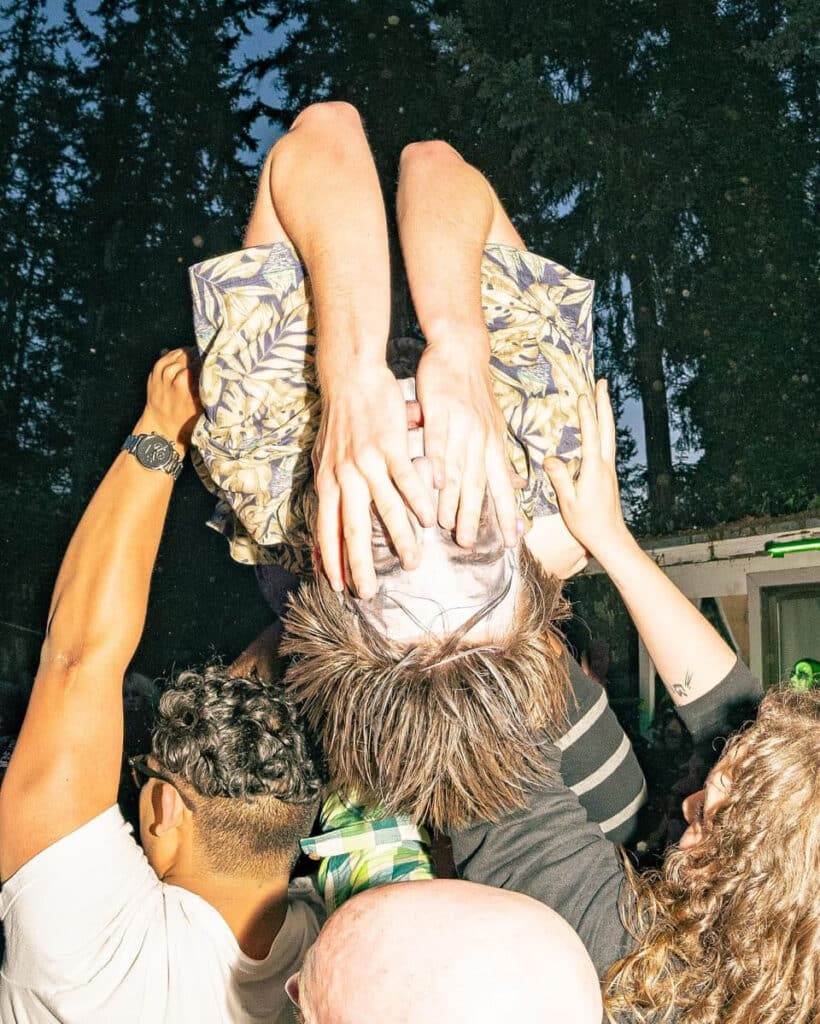 A crowd surfer at a show with alternative makeup