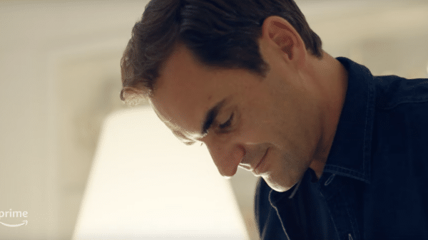 Roger Federer reading his retirement announcement. A man looking down, in a room which is brightly lit.