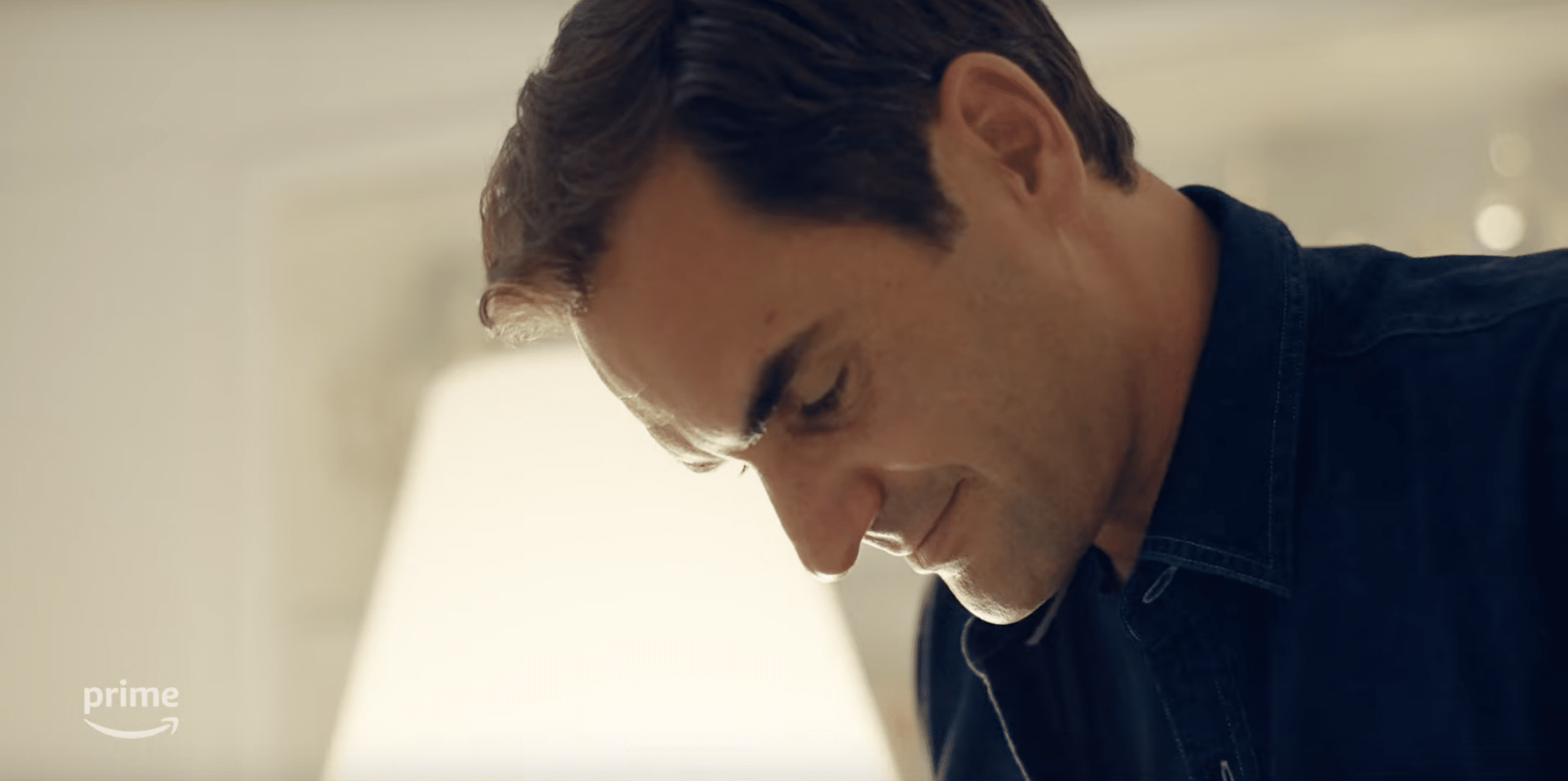 Roger Federer reading his retirement announcement. A man looking down, in a room which is brightly lit.