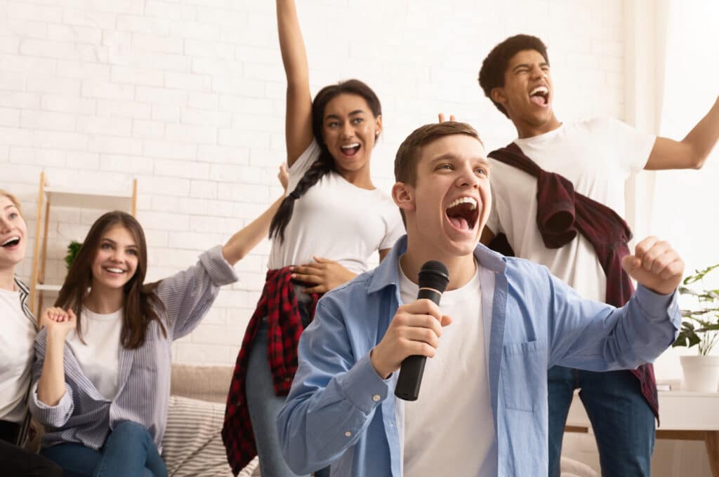 Group of friends having a great time with karaoke