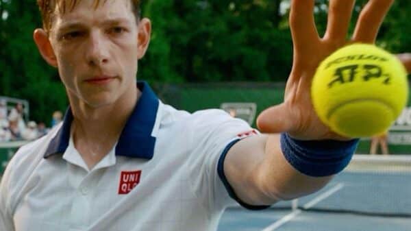 A male tennis player catching a tennis ball