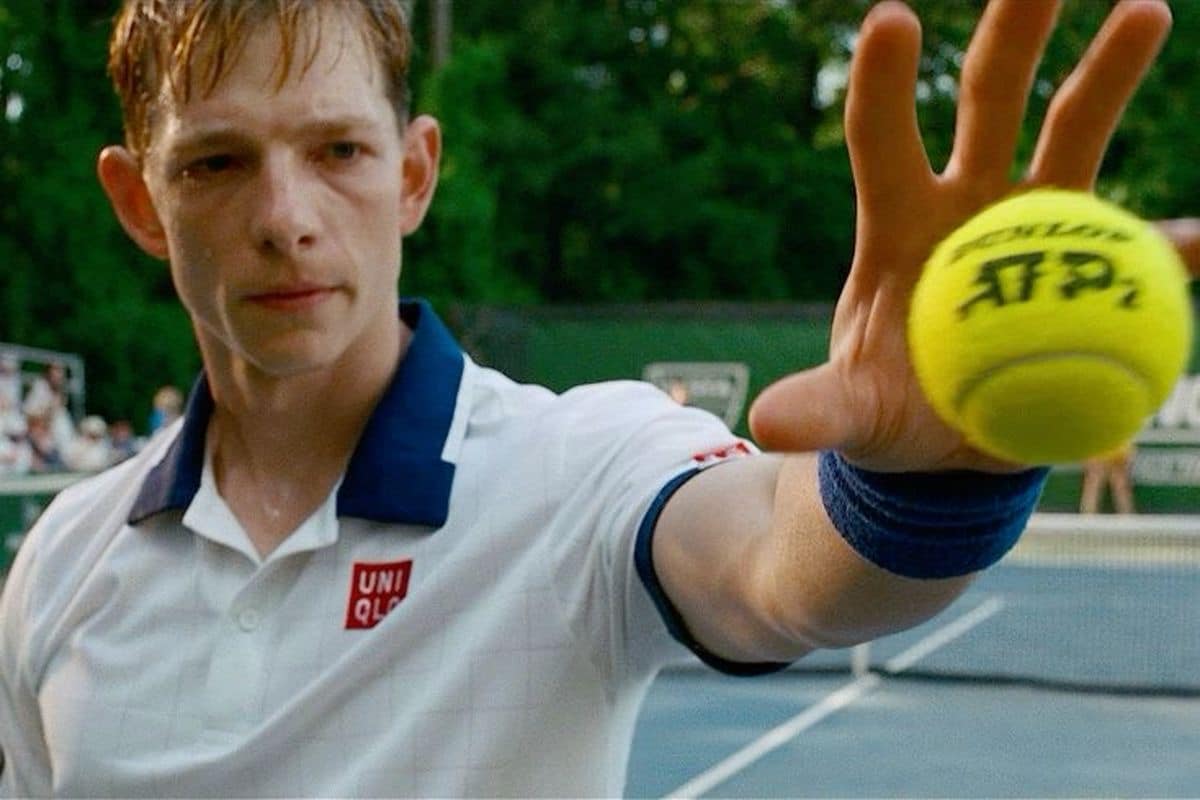 A male tennis player catching a tennis ball
