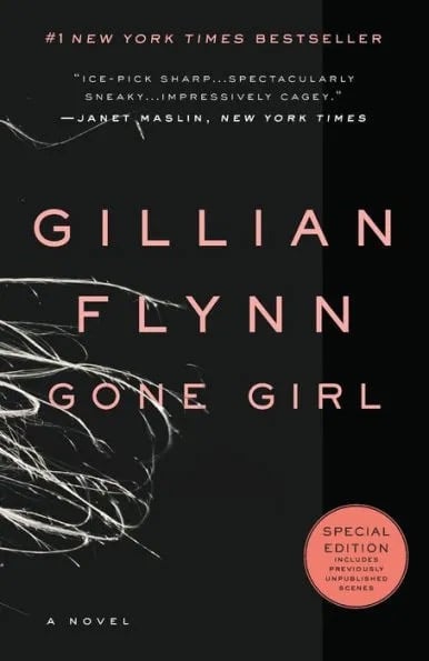 black cover with the very ends of silver hair blowing across. "Gillian Flynn gone girl" written on the cover in pale coral