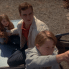 Family is sitting on the roof of the car trying to catch a signal with the baby monitor.