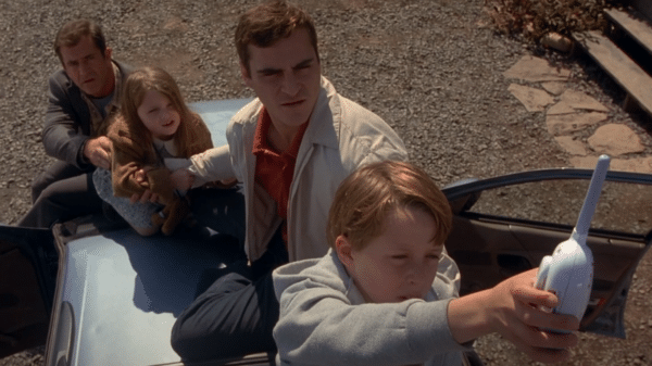 Family is sitting on the roof of the car trying to catch a signal with the baby monitor.