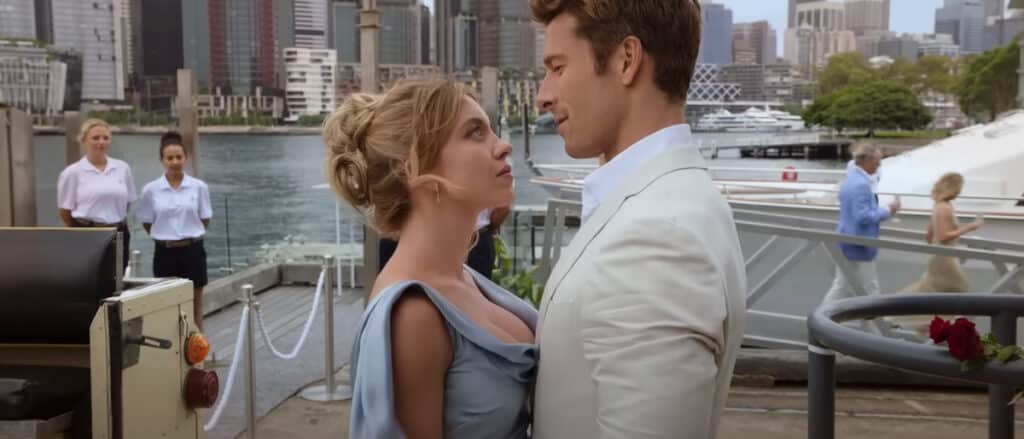 Beatrice (Sydney Sweeney) and Ben (Glen Powell) embrace each other on a dock in Australia.