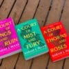 The A Court of Thorns and roses trilogy laid out on a wooden background.