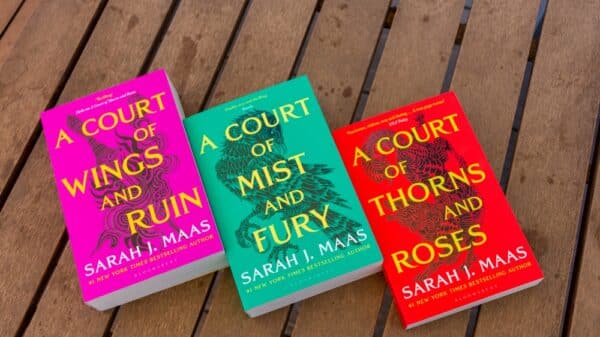 The A Court of Thorns and roses trilogy laid out on a wooden background.